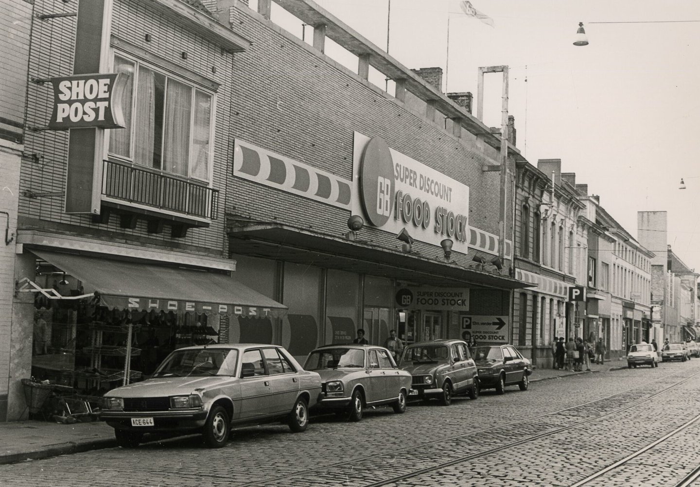 Straatbeeld met etalage van schoenwinkel Shoe Post en gevel van een GB supermarkt in Gent