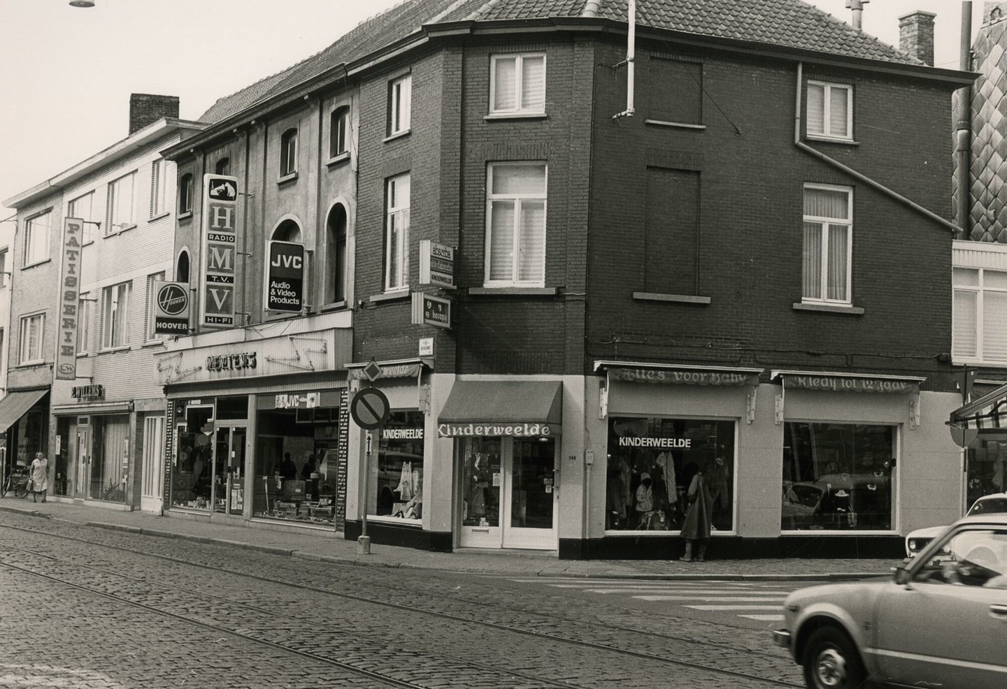 Straatbeeld met etalage van kledingwinkel Kinderweelde, elektrozaak Mertens en bakkerij Willems in Gent