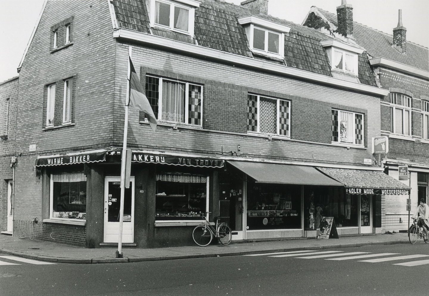 Straatbeeld met etalage van bakkerij Van Troys, een platenwinkel en kledingwinkel Adler Mode in Gent