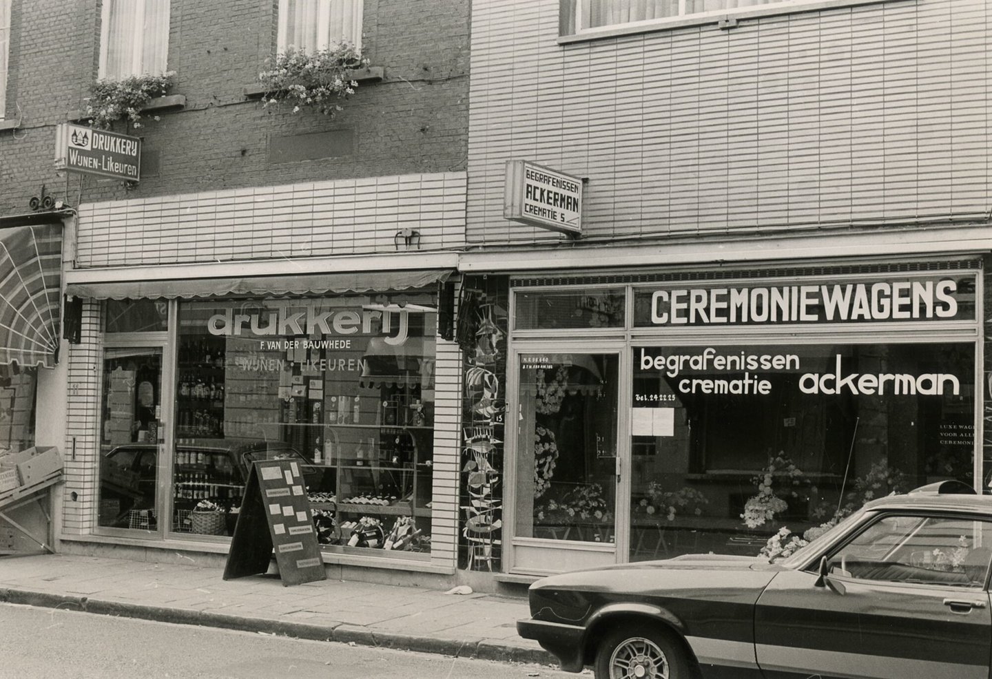 Etalages van drukkerij en drankenhandel F. Van Der Bauwhede en begrafenisondernemer Ackerman met ceremoniewagenservice in Gent