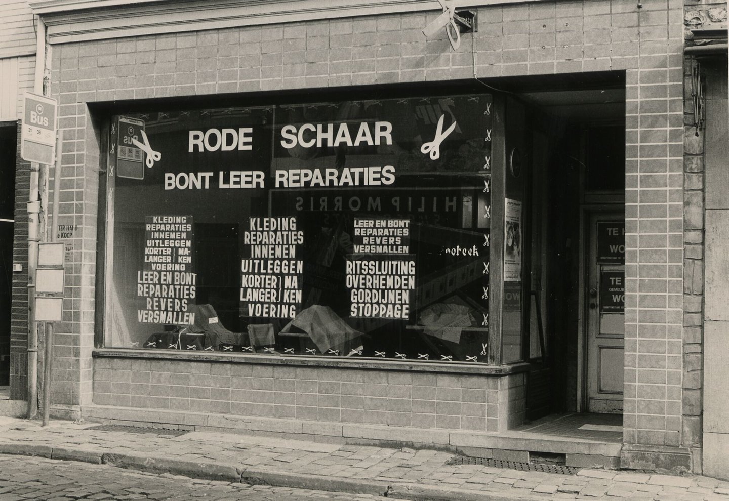 Etalage van de Rode Schaar, een winkel voor het herstellen van textiel, bont en leder in Gent