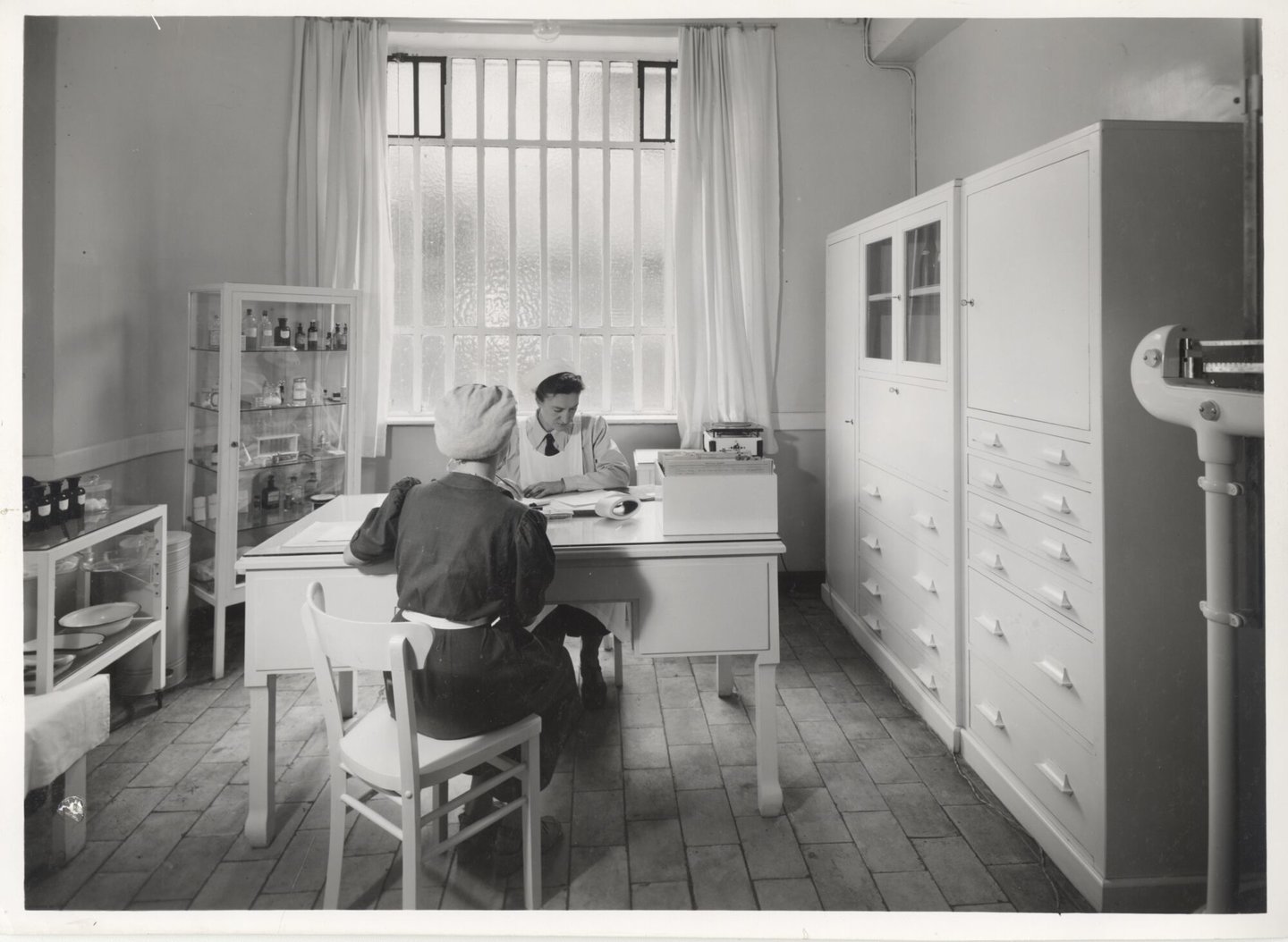 Bedrijfsverpleegster in gesprek met een textielarbeider in een UCO-vestiging