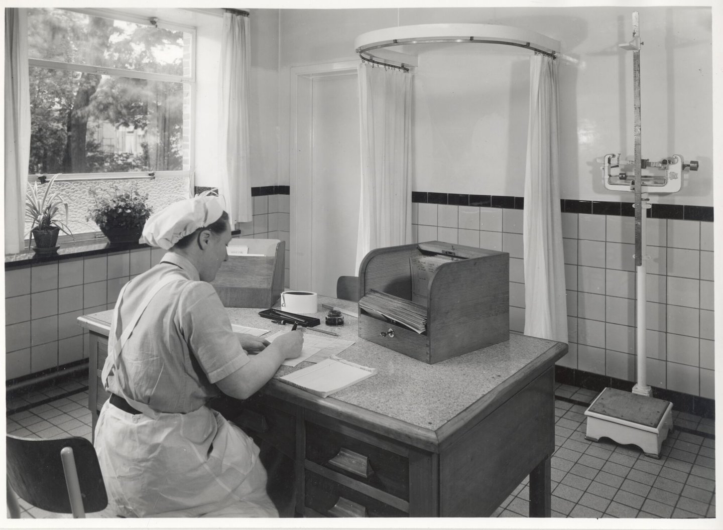 Bedrijfsverpleegster aan bureau in de infirmerie van een UCO-vestiging