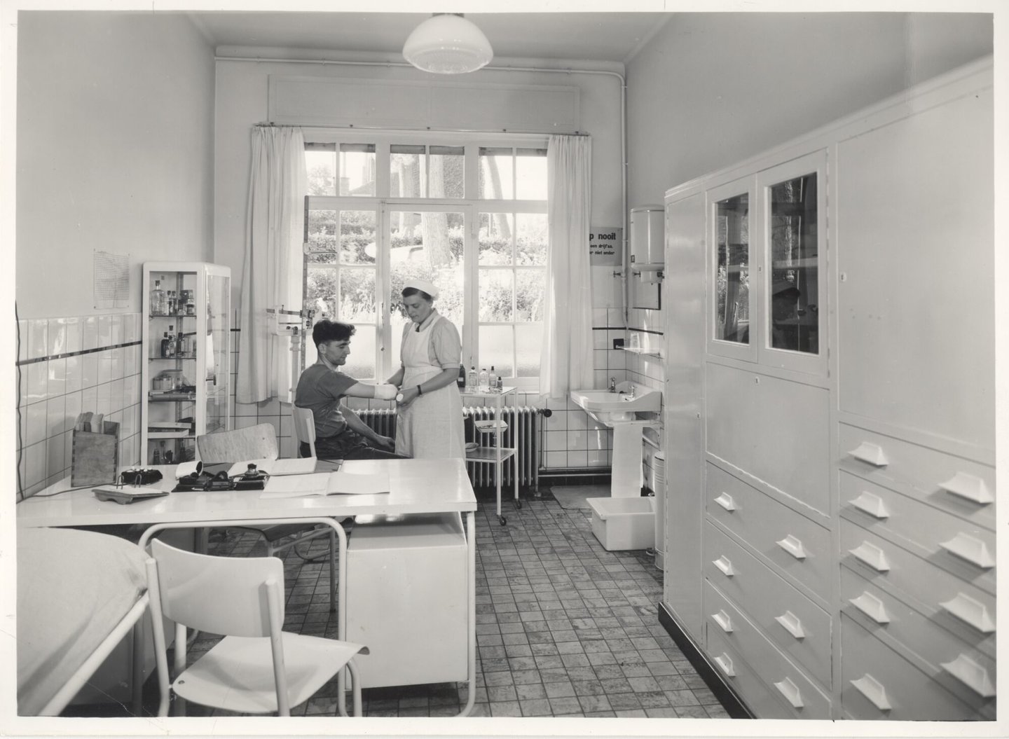 Bedrijfsverpleegster verzorgt een textielarbeider in de infirmerie van een UCO-vestiging