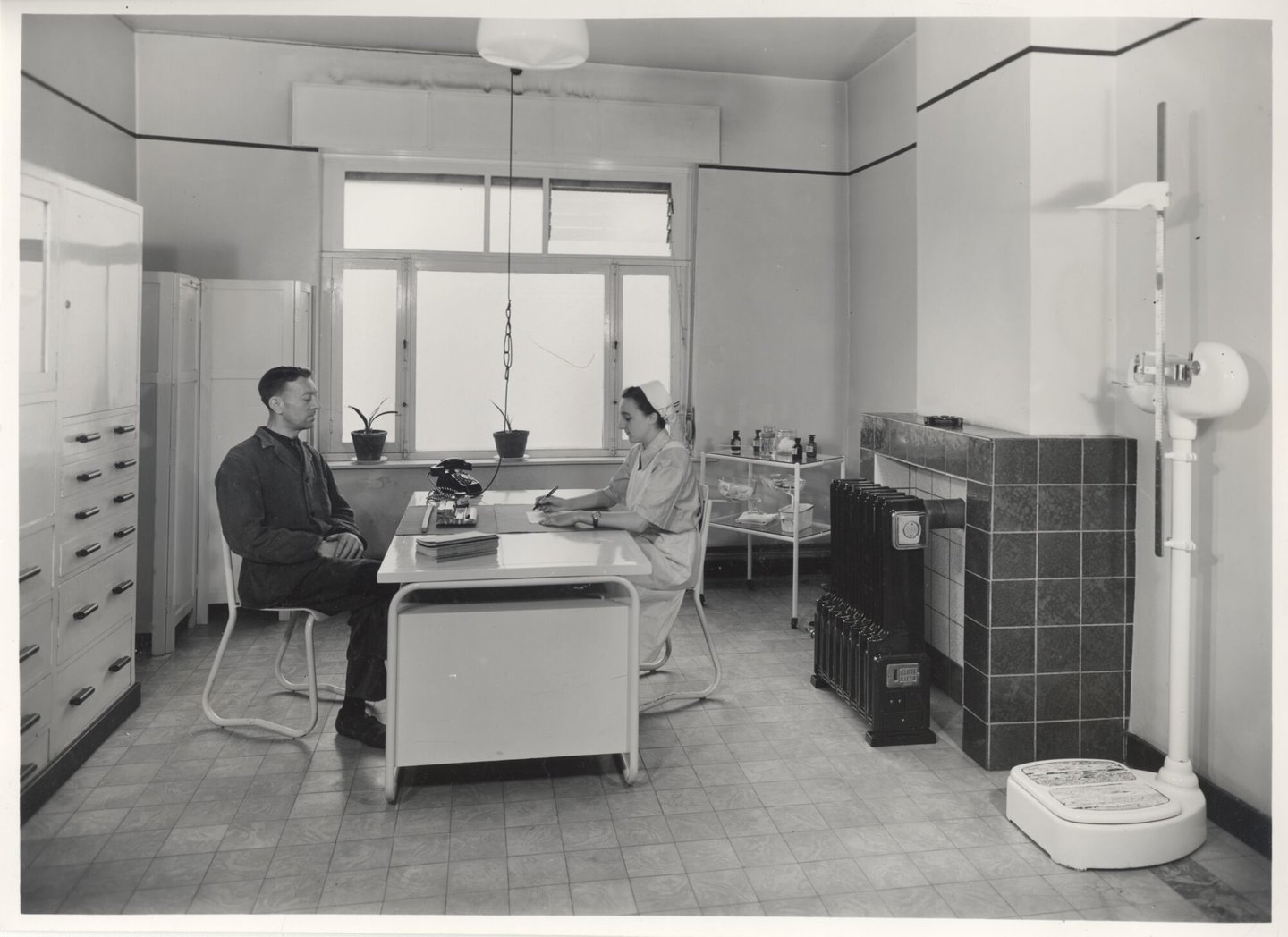 Bedrijfsverpleegster in gesprek met een textielarbeider in een UCO-vestiging