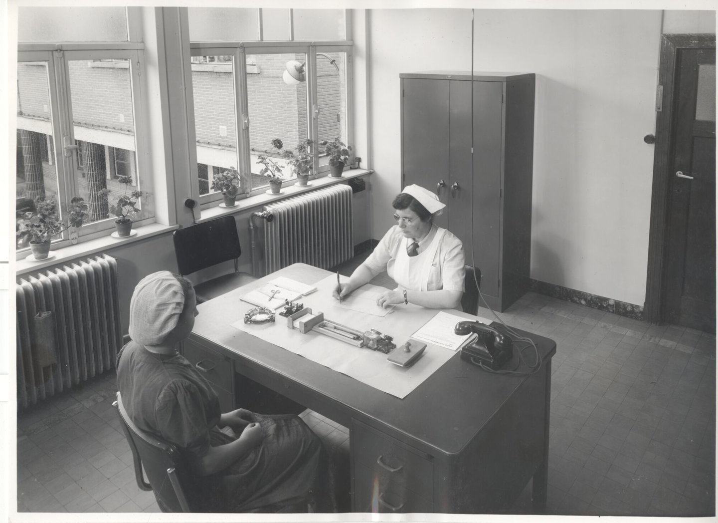 Bedrijfsverpleegster in gesprek met een textielarbeister in een UCO-vestiging