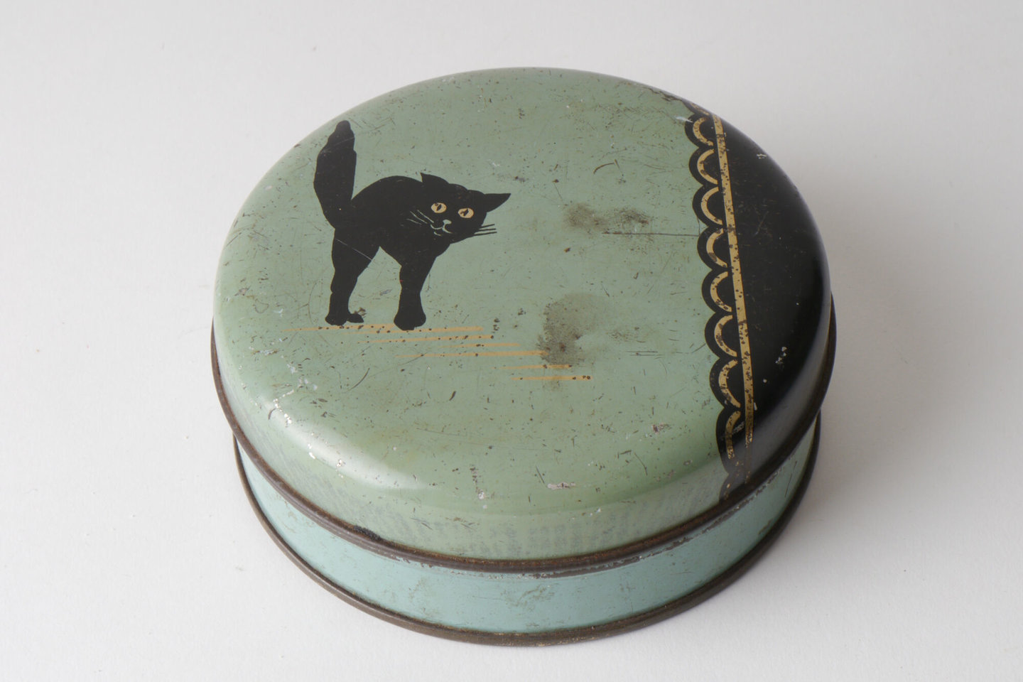 Ronde doos in blik met afbeelding van een zwarte kat