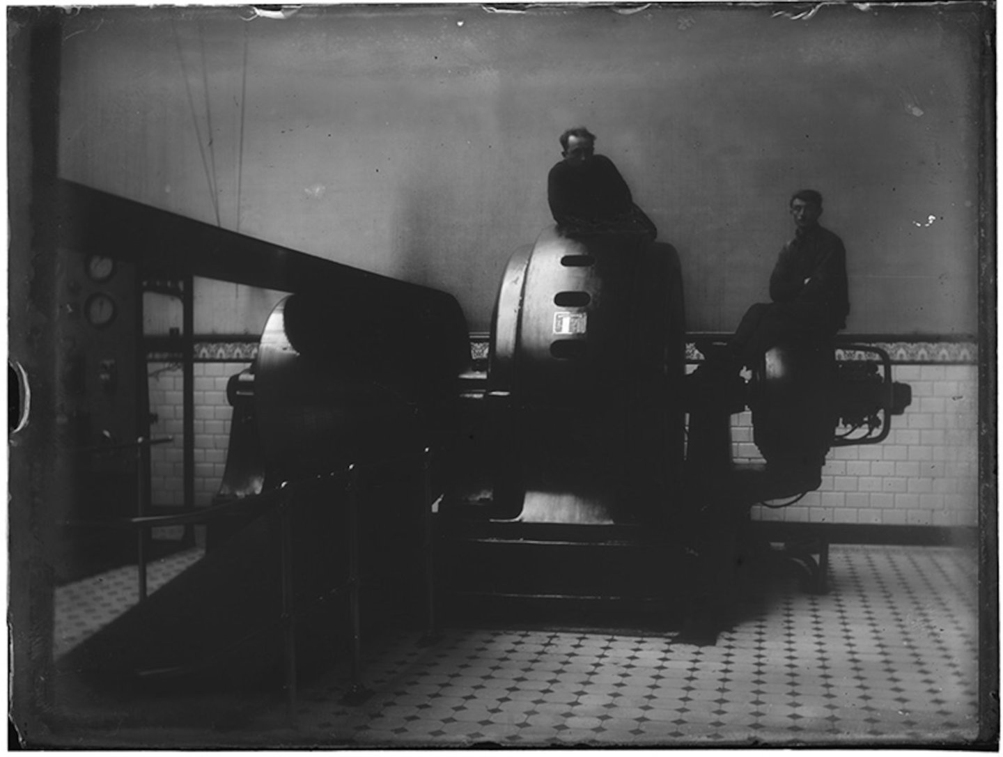 Binnenzicht machinekamer met poserende mannen zittend op een alternator