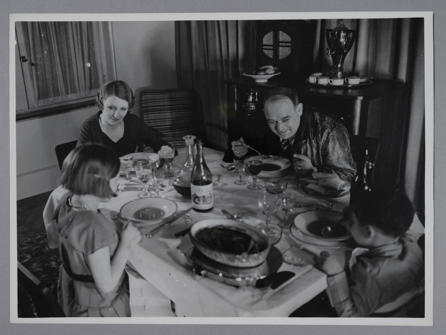Gezin zit aan een feestelijk tafel en eet samen soep