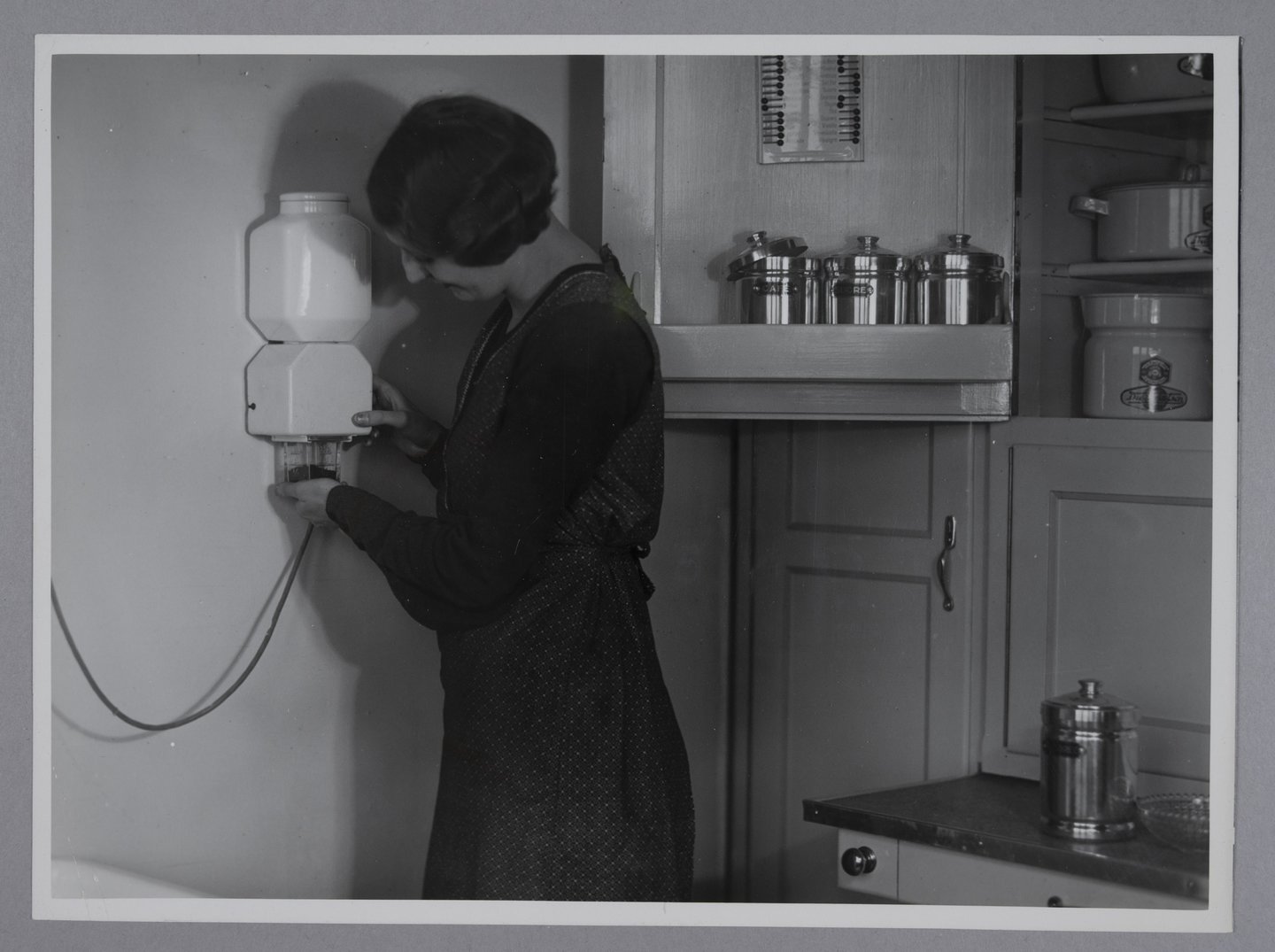 Vrouw maalt koffie met een elektrische koffiemolen