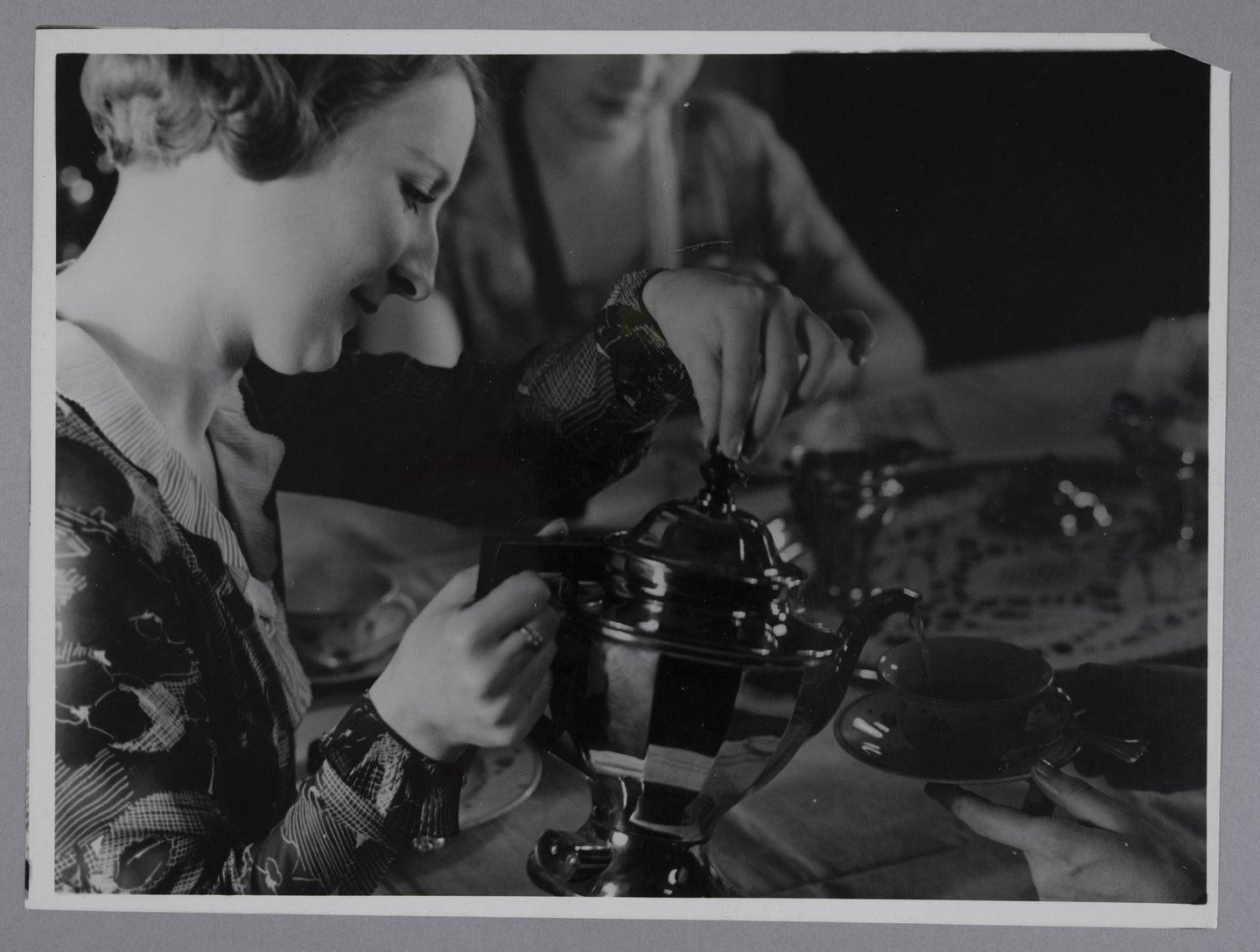 Vrouw schenkt thee met een elektrische theepot