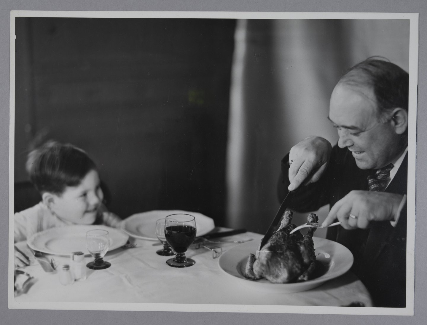 Vader snijdt een gebraden kip aan