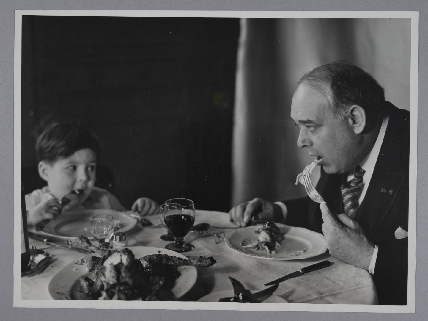 Vader en zoon eten gebraden kip