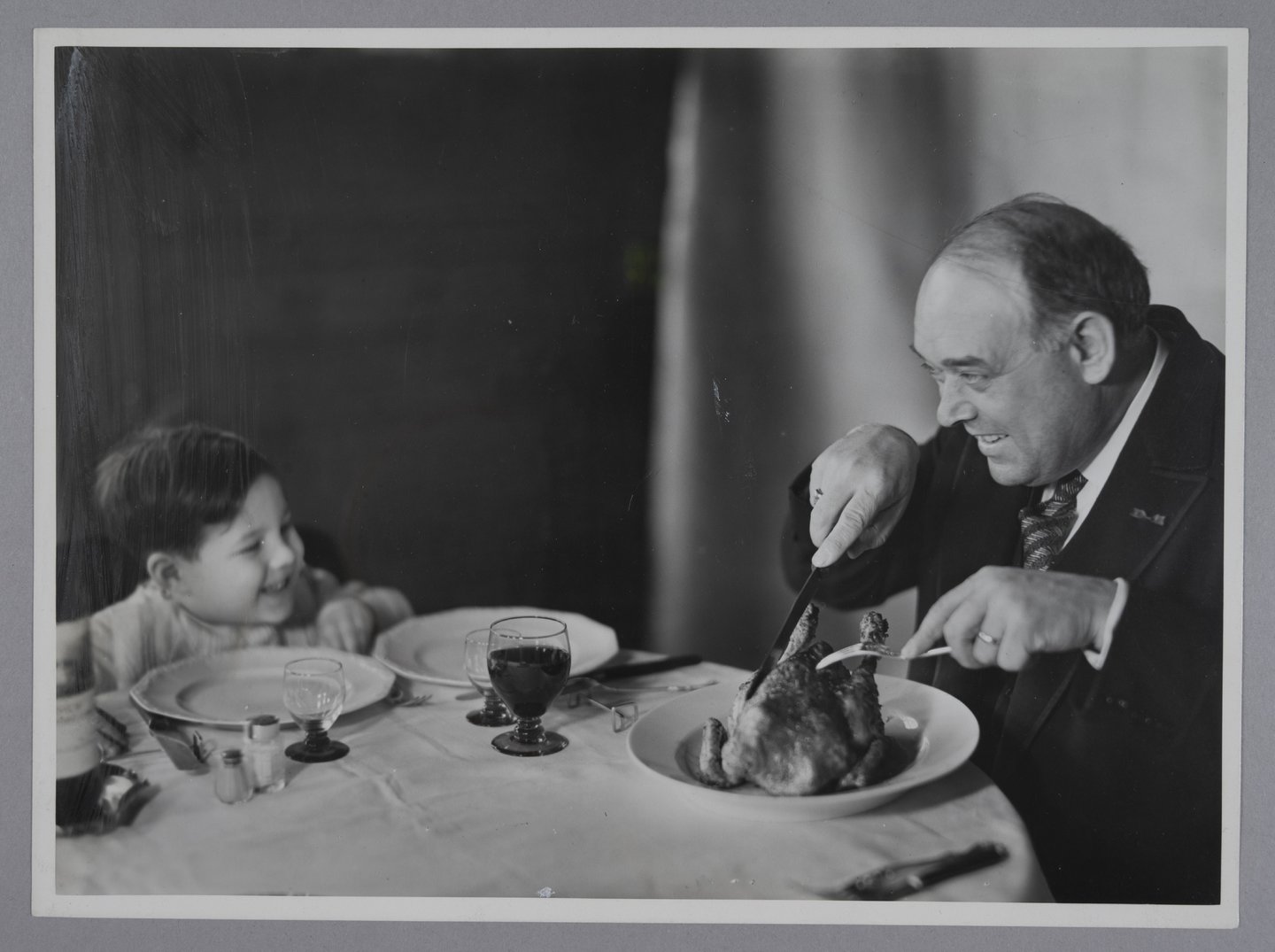 Vader snijdt een gebraden kip aan