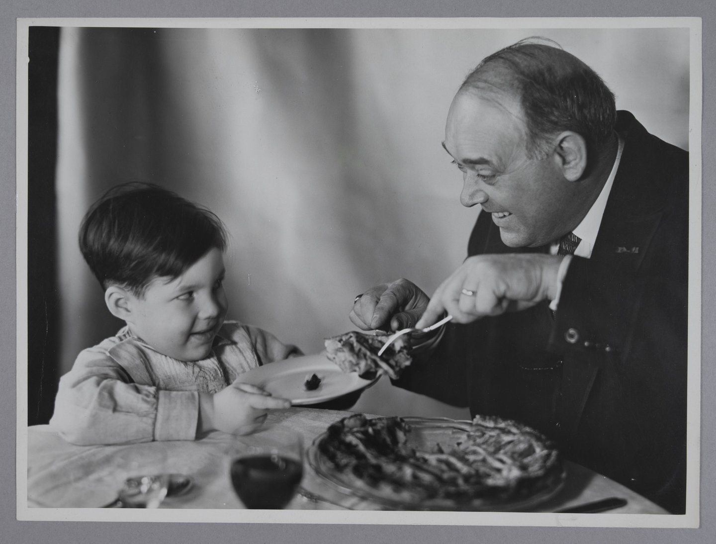 Vader legt een stuk taart op het bord van de zoon