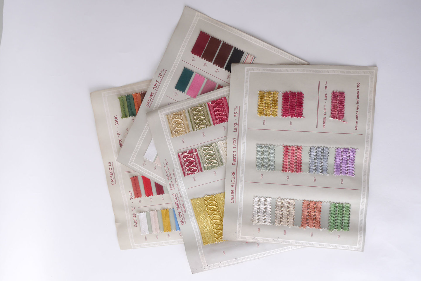 Losse bladzijden uit staalboek met textielstalen om passement te vervaardigen