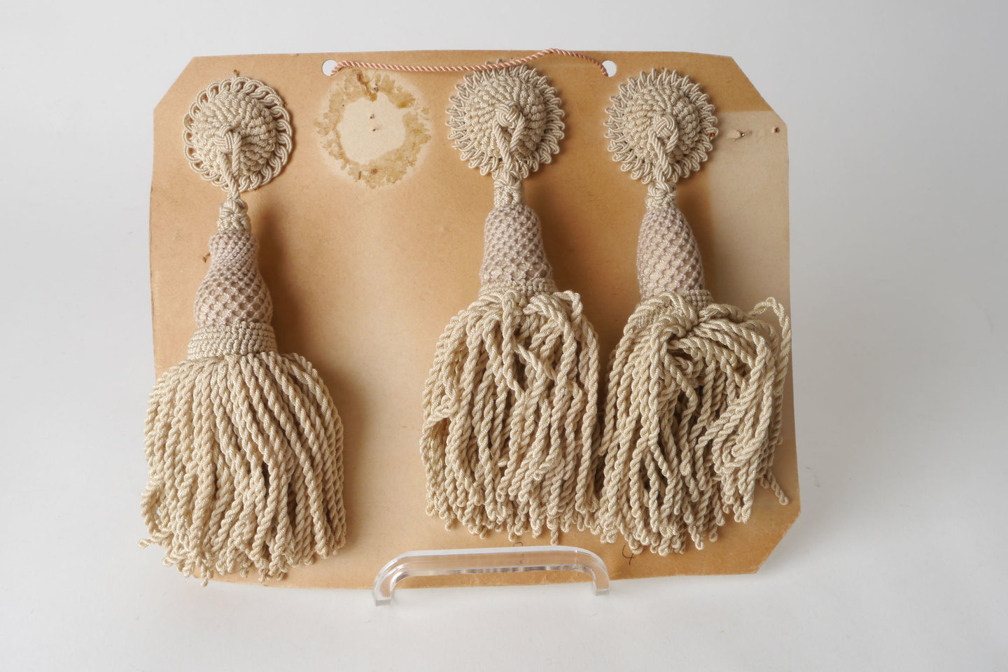 Staalkaart met gelijkaardige macarons of rozetten met kwast als onderdeel voor het vervaardigen van passement