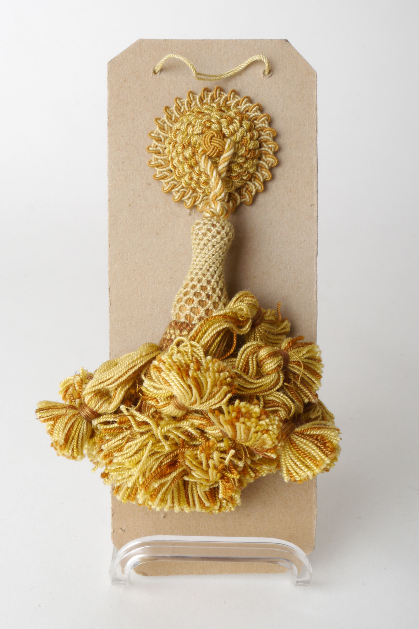 Staalkaart met  macaron of rozet met kwast als onderdeel voor het vervaardigen van passement