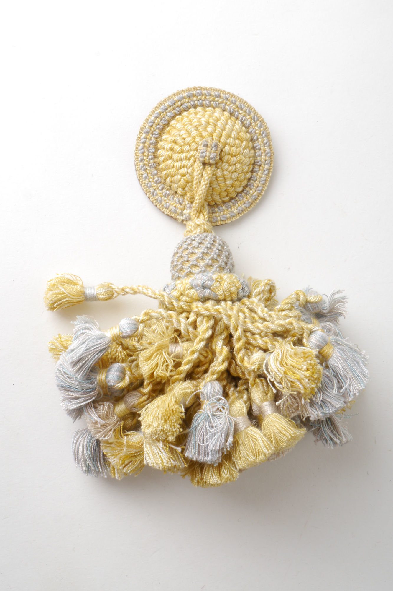 Macaron of rozet met kwast als onderdeel voor het vervaardigen van passement