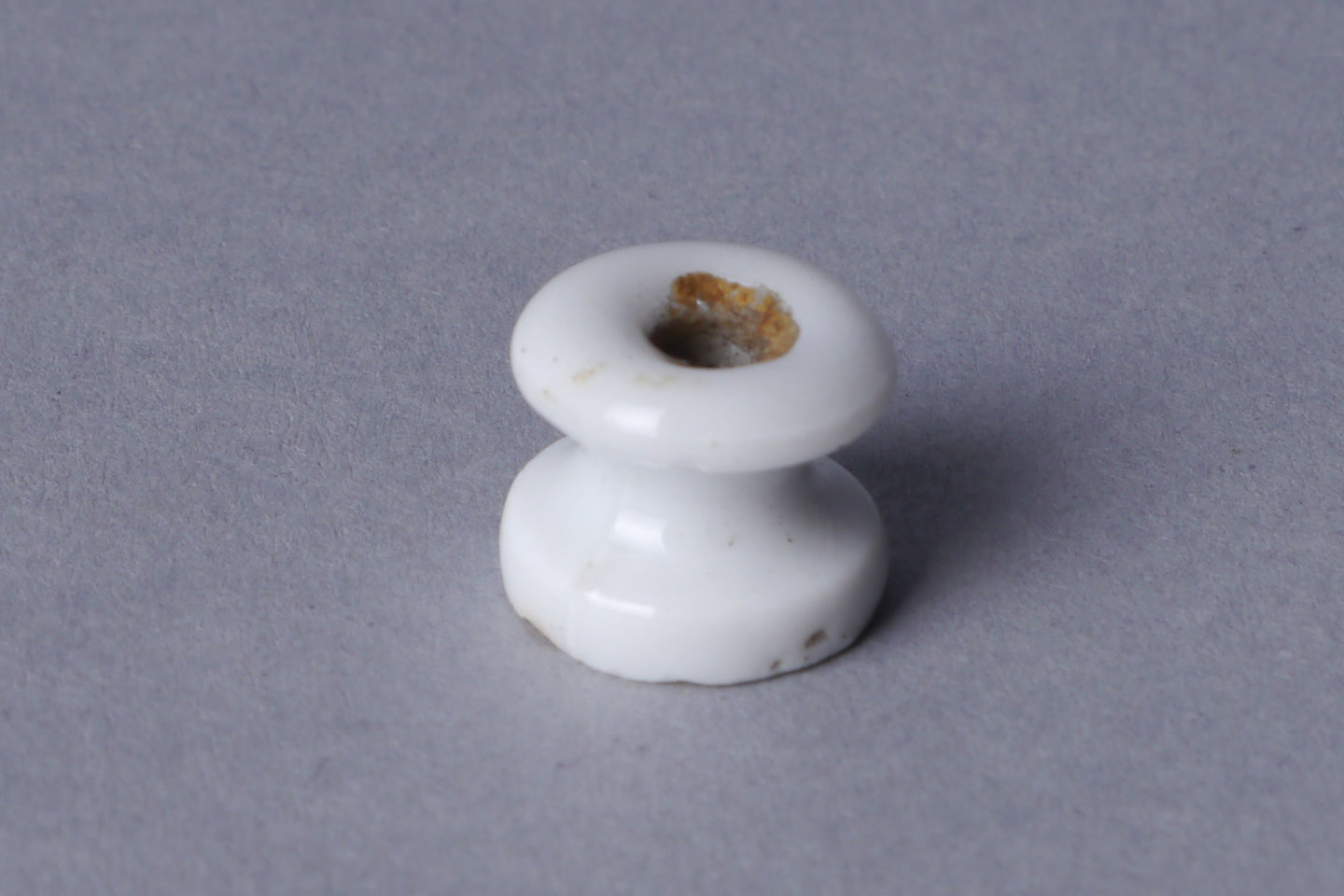 Isolator in witte porselein voor elektrische bekabeling