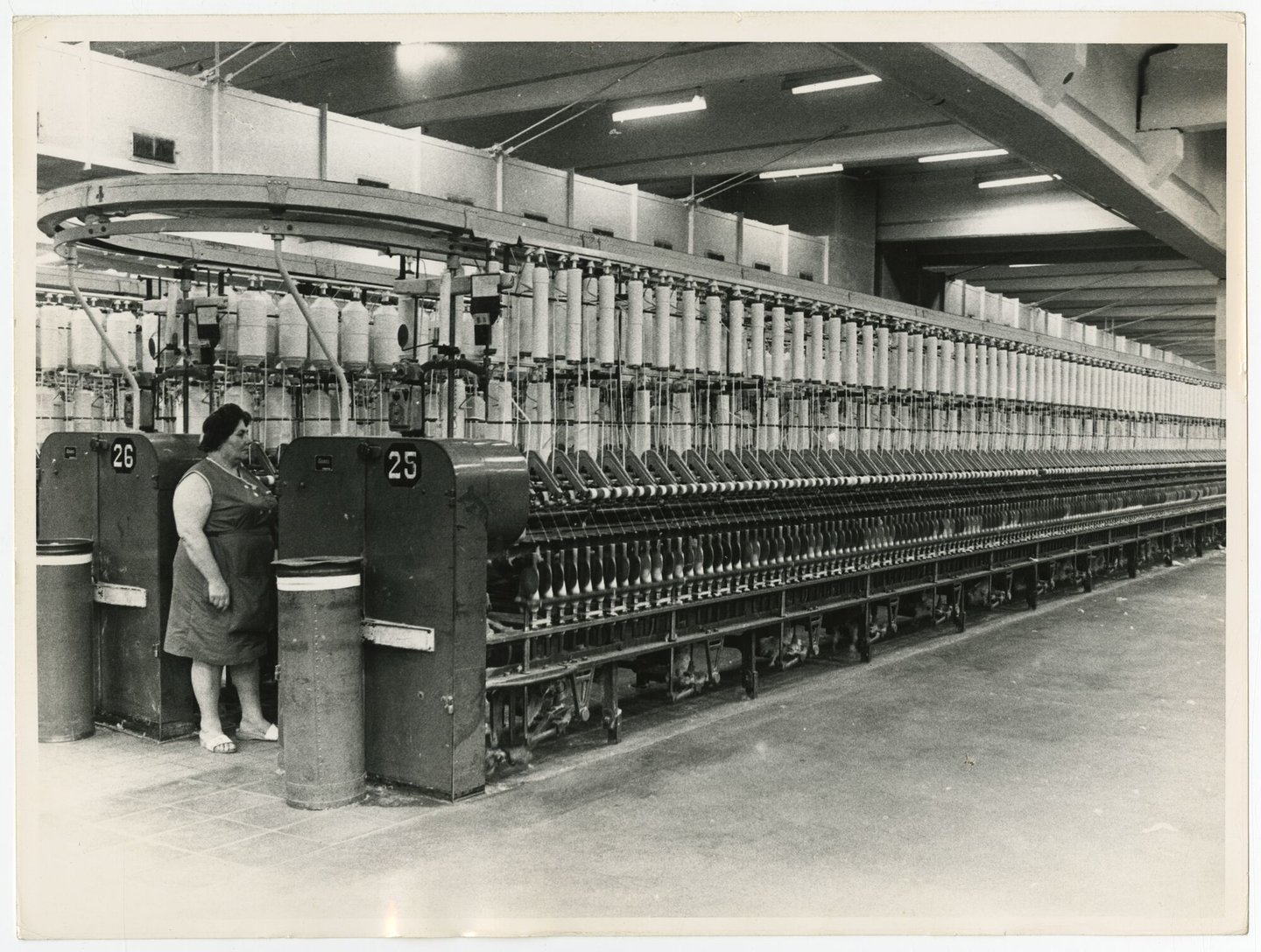Arbeidster aan ringspinmachine in spinnerij E.J. Braun