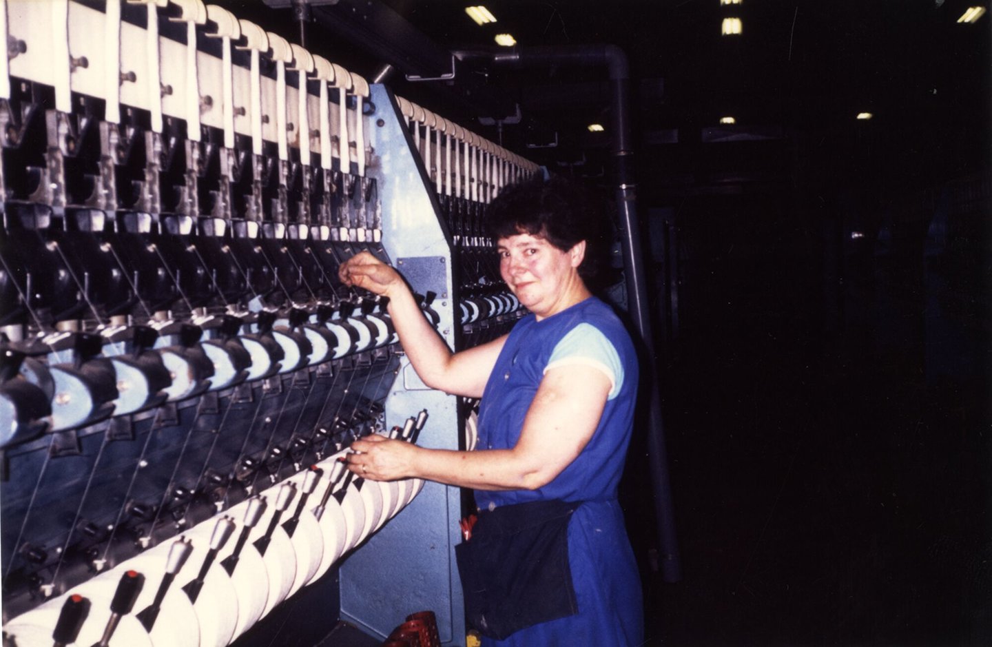 Arbeidster aan een spinmachine in UCO Braun in Gent